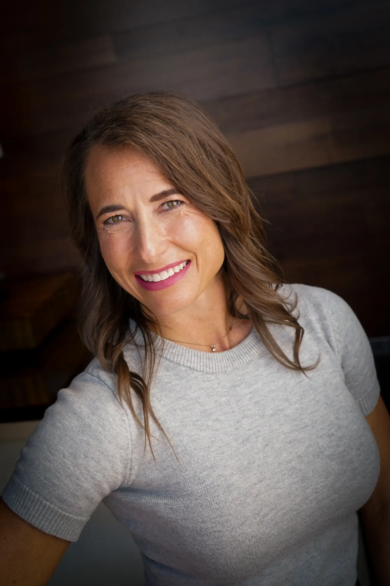 Trisha Barr, smiling, in a grey top